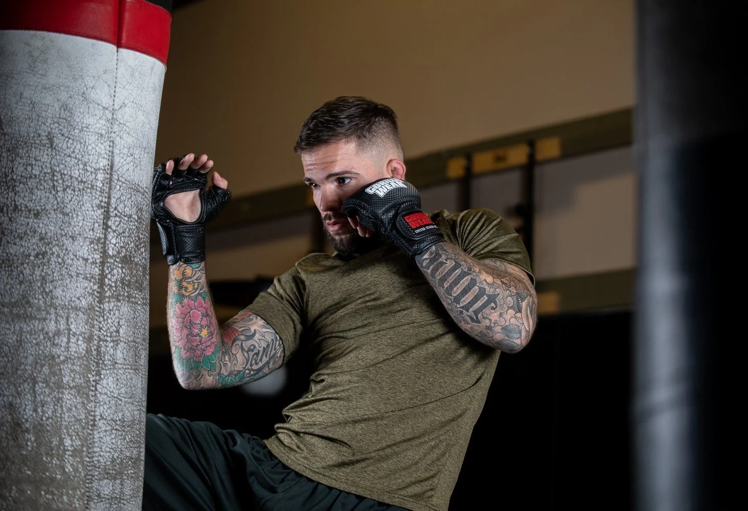 Male training in a gym, punching a bag.