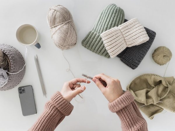 woman knitting a hat in various colors