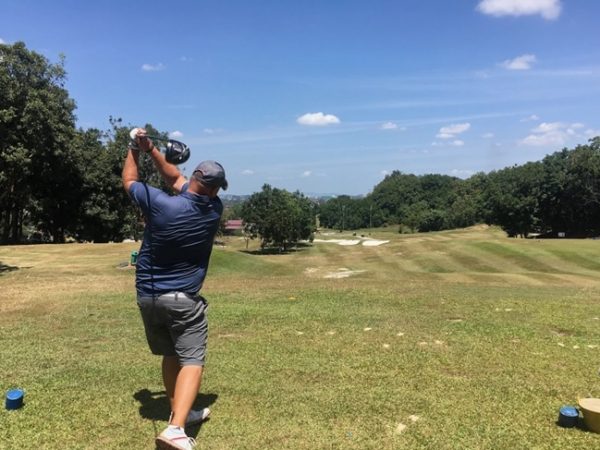 a person playing golf with a hybrid club