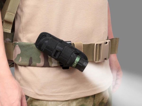 person wearing beige shirt, camo pants with a flashlight attached to his tactical belt